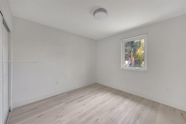 empty room with light wood finished floors and baseboards