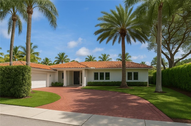 2341 Keystone, North Miami, FL 33181 - view of front of home with an attached garage, stucco siding, decorative driveway, and a front yard