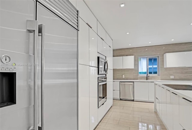 2341 Keystone, North Miami, FL 33181 - kitchen with stainless steel appliances, modern cabinets, white cabinets, light countertops, and backsplash