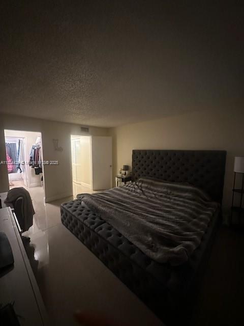 9351 Fontainebleau Blvd Unit B122, Miami, FL 33172 - bedroom featuring a walk in closet and a textured ceiling