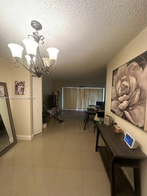 9351 Fontainebleau Blvd Unit B122, Miami, FL 33172 - corridor featuring a textured ceiling, a chandelier, and light tile patterned flooring