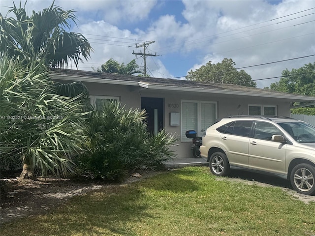 10330 SW 51st St, Miami, FL 33165 - view of home's exterior with a shingled roof, a yard, and stucco siding