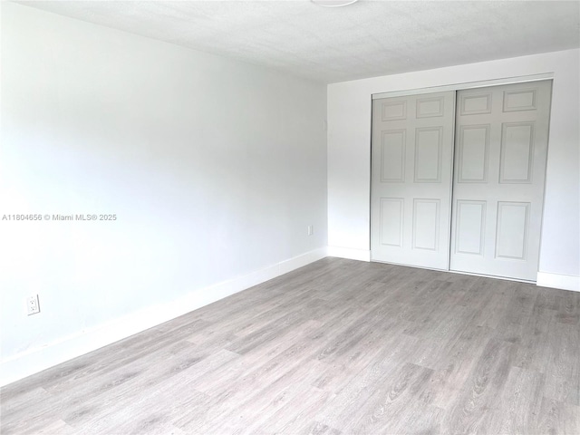 2421 N 56th Ter, Hollywood, FL 33021 - unfurnished bedroom featuring a closet, wood finished floors, and baseboards