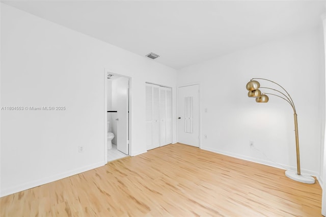 1051 Meridian Ave Unit 1D, Miami Beach, FL 33139 - unfurnished bedroom featuring wood finished floors and ensuite bathroom