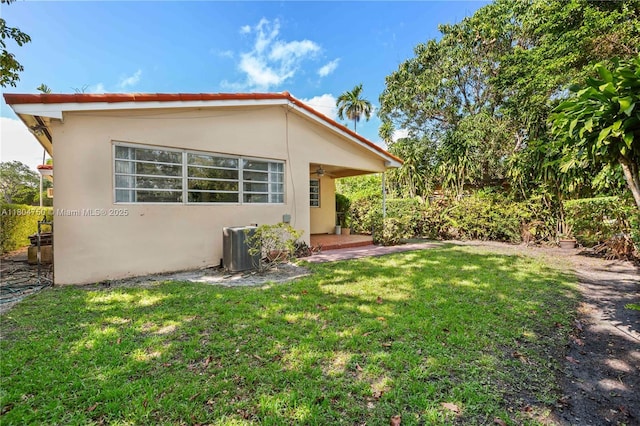 1242 Sevilla Ave, Coral Gables, FL 33134 - rear view of house featuring stucco siding, a yard, and cooling unit