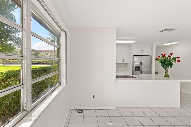1242 Sevilla Ave, Coral Gables, FL 33134 - kitchen featuring stainless steel refrigerator with ice dispenser, baseboards, light countertops, white cabinets, and light tile patterned floors