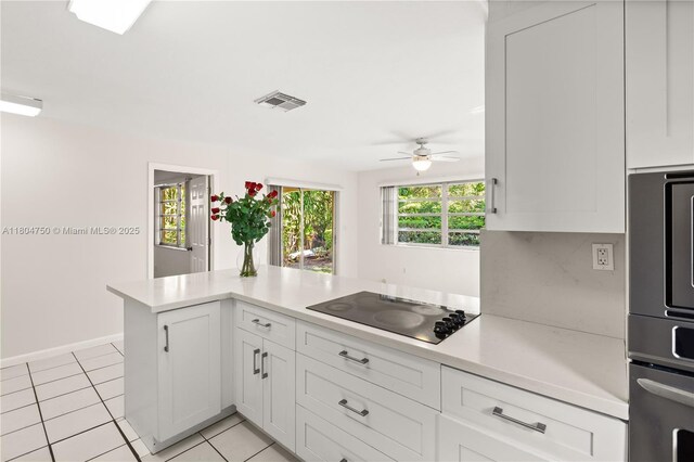 1242 Sevilla Ave, Coral Gables, FL 33134 - kitchen featuring black electric cooktop, light countertops, a ceiling fan, light tile patterned floors, and baseboards
