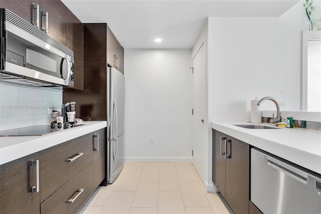 17315 Collins Ave Unit 1008, Sunny Isles Beach, FL 33160 - kitchen with stainless steel appliances, a sink, light countertops, dark brown cabinets, and recessed lighting