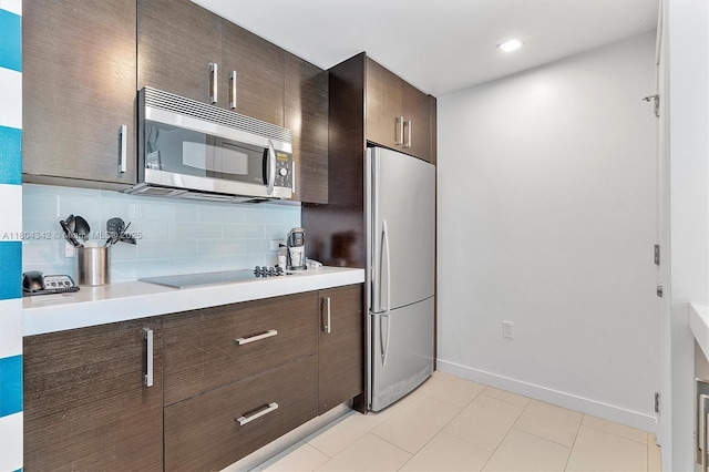 17315 Collins Ave Unit 1008, Sunny Isles Beach, FL 33160 - kitchen featuring appliances with stainless steel finishes, light countertops, decorative backsplash, and dark brown cabinets
