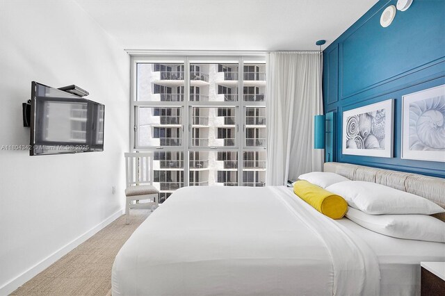 17315 Collins Ave Unit 1008, Sunny Isles Beach, FL 33160 - bedroom featuring light carpet, baseboards, and expansive windows