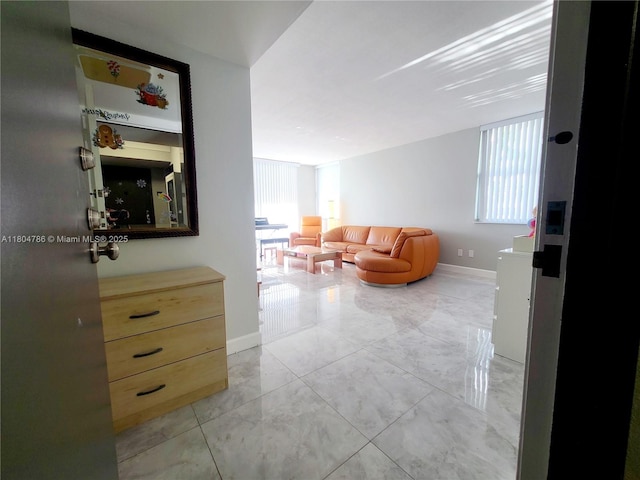 16565 NE 26th Ave Unit 2B, North Miami Beach, FL 33160 - hall with plenty of natural light, baseboards, and light marble finish floors