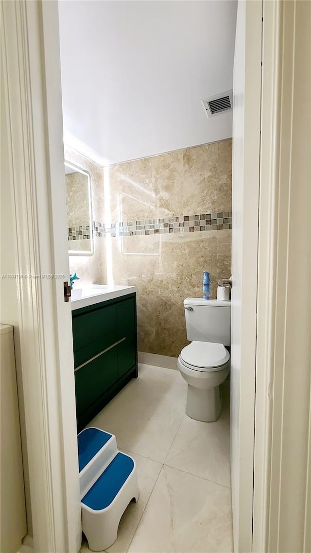 16565 NE 26th Ave Unit 2B, North Miami Beach, FL 33160 - bathroom featuring vanity, toilet, and tile walls