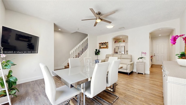 2250 NE 42nd Cir, Homestead, FL 33033 - dining area with arched walkways, ceiling fan, light wood-style flooring, stairs, and a textured ceiling