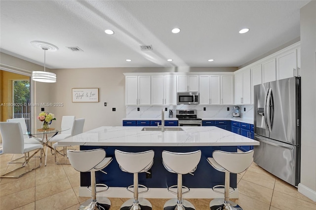 4470 E Seneca Ave, Weston, FL 33332 - kitchen featuring stainless steel appliances, blue cabinets, white cabinets, light tile patterned floors, and recessed lighting