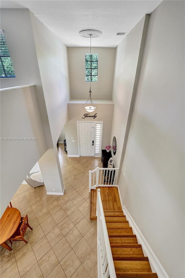 4470 E Seneca Ave, Weston, FL 33332 - entryway with light tile patterned floors, a textured ceiling, baseboards, and stairs