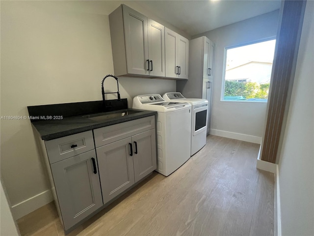 13000 SW 69th Ct, Pinecrest, FL 33156 - washroom with light wood-style floors, washer and clothes dryer, baseboards, and cabinet space