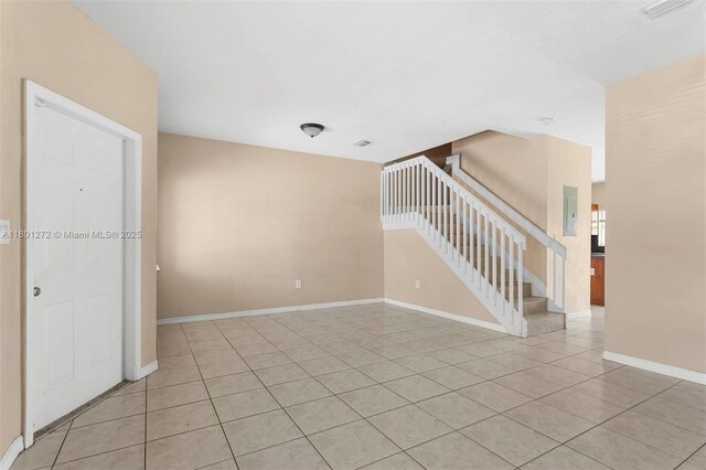 2946 SE 15th Ter, Homestead, FL 33035 - empty room with stairway, light tile patterned flooring, and baseboards