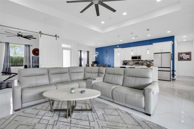 1020 Rush Ave, Lehigh Acres, FL 33972 - living room featuring a ceiling fan, a barn door, recessed lighting, and light marble finish flooring