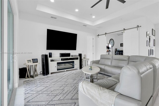 1020 Rush Ave, Lehigh Acres, FL 33972 - living room with a barn door, recessed lighting, a ceiling fan, and a tray ceiling