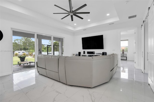 1020 Rush Ave, Lehigh Acres, FL 33972 - living room featuring a raised ceiling, a ceiling fan, recessed lighting, healthy amount of natural light, and light marble finish flooring