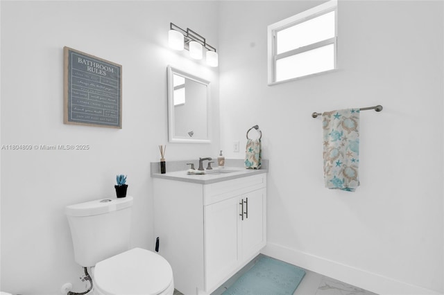 1020 Rush Ave, Lehigh Acres, FL 33972 - bathroom with toilet, vanity, marble look tile flooring, and baseboards