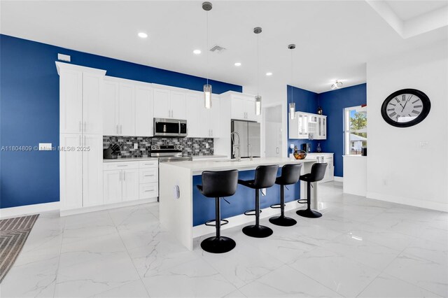 1020 Rush Ave, Lehigh Acres, FL 33972 - kitchen with appliances with stainless steel finishes, light marble finish floors, baseboards, a kitchen breakfast bar, and decorative backsplash