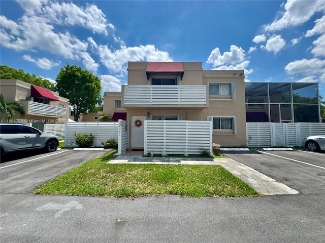 14367 SW 96th Ln, Miami, FL 33186 - view of property with uncovered parking, a balcony, stucco siding, and fence