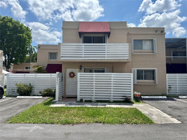 14367 SW 96th Ln, Miami, FL 33186 - townhome / multi-family property featuring uncovered parking, stucco siding, and a balcony