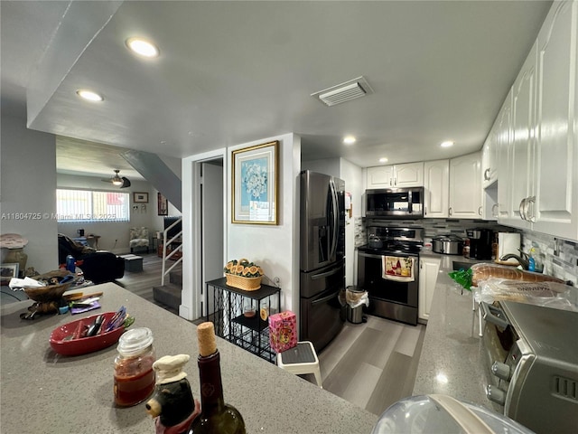 14367 SW 96th Ln, Miami, FL 33186 - kitchen featuring appliances with stainless steel finishes, white cabinets, light wood-style floors, recessed lighting, and backsplash