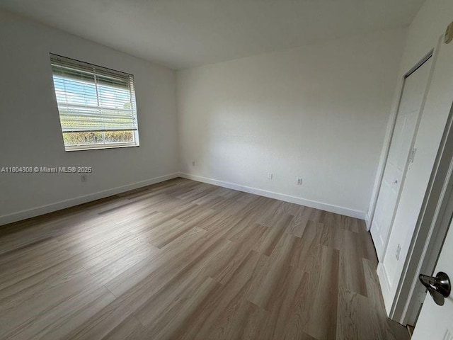 unfurnished bedroom with wood finished floors and baseboards
