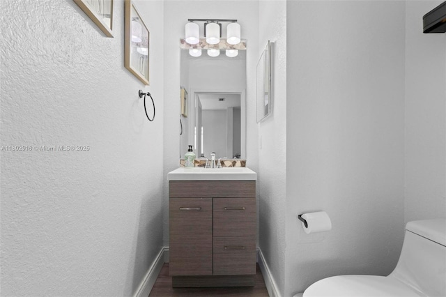 922 SW 148th Pl, Miami, FL 33194 - half bath with toilet, vanity, a textured wall, baseboards, and wood finished floors