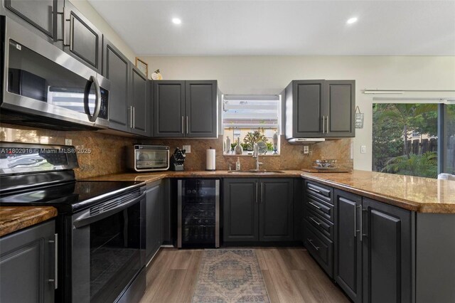 922 SW 148th Pl, Miami, FL 33194 - kitchen featuring stainless steel microwave, black / electric stove, beverage cooler, a sink, and plenty of natural light