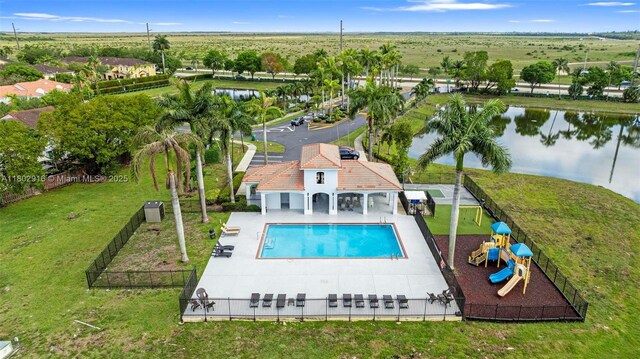922 SW 148th Pl, Miami, FL 33194 - view of swimming pool featuring a water view, a patio, and central AC