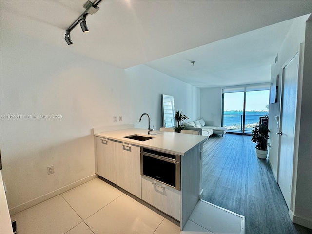 501 NE 31st St Unit 2903, Miami, FL 33137 - kitchen with a sink, track lighting, a peninsula, light countertops, and baseboards