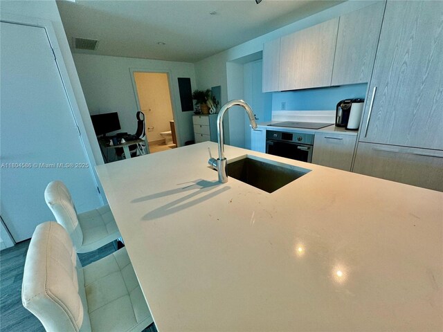 501 NE 31st St Unit 2903, Miami, FL 33137 - kitchen featuring wall oven, light countertops, a sink, modern cabinets, and black electric cooktop