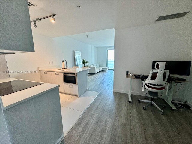 501 NE 31st St Unit 2903, Miami, FL 33137 - kitchen featuring black electric cooktop, light wood-style floors, a sink, modern cabinets, and a peninsula