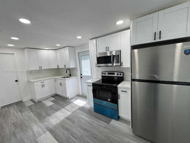 1794 NW 74th Ter, Miami, FL 33147 - kitchen featuring appliances with stainless steel finishes, a sink, light countertops, white cabinetry, and recessed lighting
