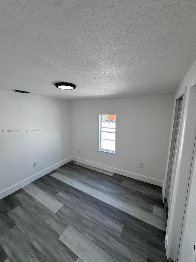 1794 NW 74th Ter, Miami, FL 33147 - unfurnished room with a textured ceiling, baseboards, and dark wood-type flooring