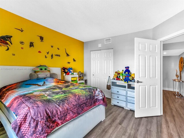 3800 Hillcrest Dr Unit 907, Hollywood, FL 33021 - bedroom featuring wood finished floors, a closet, and a textured ceiling