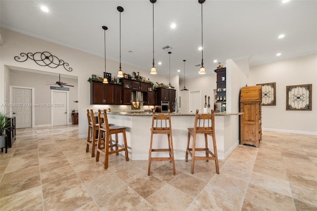 3324 Miller Ave, Lake Placid, FL 33852 - kitchen featuring stainless steel oven, dark brown cabinetry, a kitchen bar, recessed lighting, and decorative light fixtures