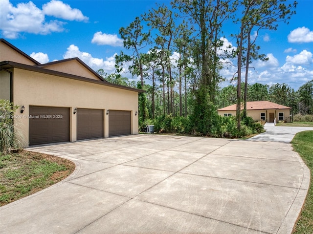3324 Miller Ave, Lake Placid, FL 33852 - view of property exterior with concrete driveway, stucco siding, and a garage