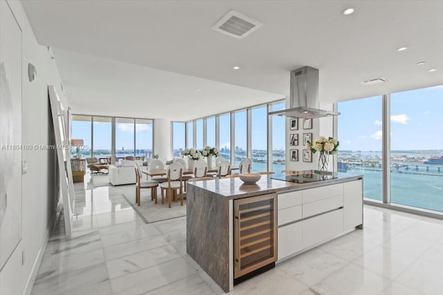 700 NE 26th Ter Unit 3903, Miami, FL 33137 - kitchen featuring beverage cooler, expansive windows, island range hood, light marble finish flooring, and black electric stovetop
