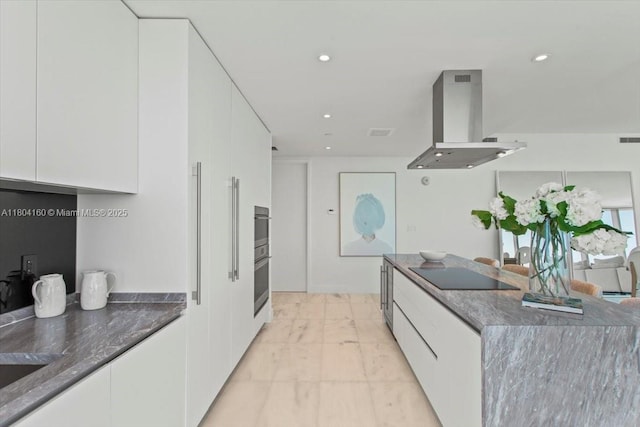 700 NE 26th Ter Unit 3903, Miami, FL 33137 - kitchen featuring island exhaust hood, black electric stovetop, light marble finish floors, modern cabinets, and white cabinetry