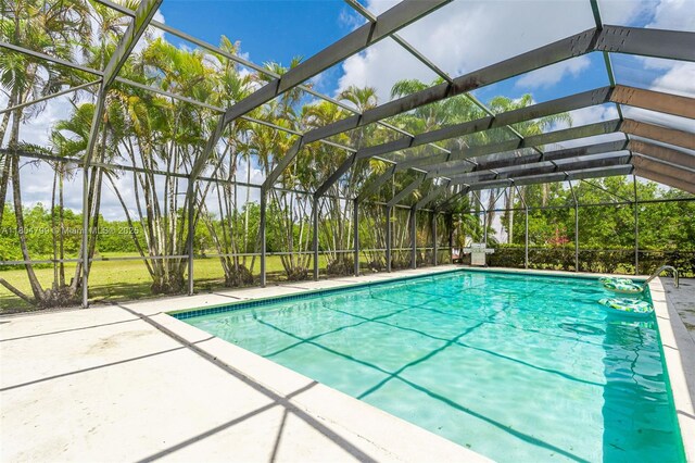 21800 SW 152nd Ave, Miami, FL 33170 - outdoor pool with a patio area, glass enclosure, and view of scattered trees