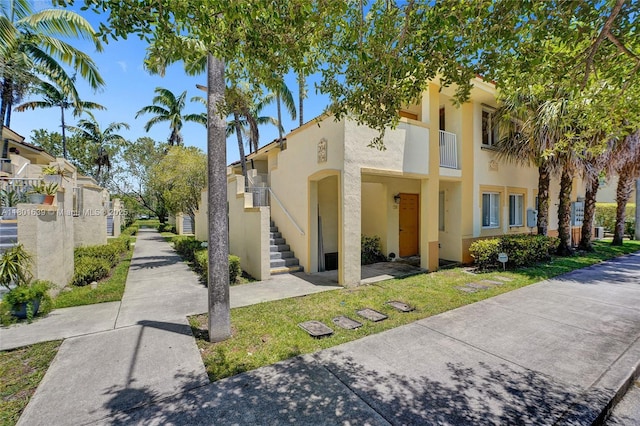 6235 SW 47th Mnr Unit 204, Davie, FL 33314 - view of front of property featuring stucco siding, stairs, and a balcony