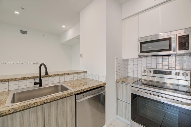 7330 NW 114th Ave Unit 304-5, Doral, FL 33178 - kitchen with stainless steel appliances, a sink, modern cabinets, decorative backsplash, and white cabinets