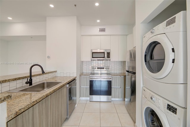 7330 NW 114th Ave Unit 304-5, Doral, FL 33178 - kitchen featuring appliances with stainless steel finishes, stacked washer / dryer, a sink, modern cabinets, and light tile patterned floors