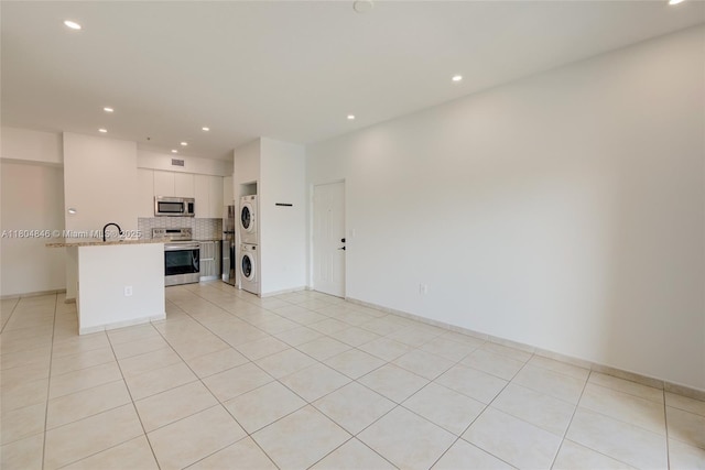 7330 NW 114th Ave Unit 304-5, Doral, FL 33178 - unfurnished living room with stacked washer and clothes dryer, recessed lighting, light tile patterned floors, and baseboards