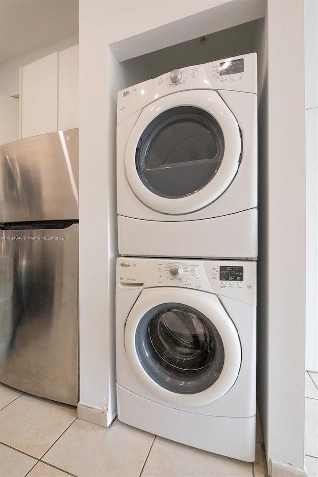 7330 NW 114th Ave Unit 304-5, Doral, FL 33178 - laundry area featuring stacked washing machine and dryer and light tile patterned flooring