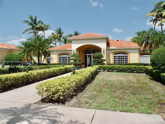 7330 NW 114th Ave Unit 304-5, Doral, FL 33178 - mediterranean / spanish-style house with stucco siding, a tile roof, and a front yard